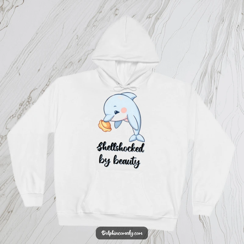 Funny Dolphin Hoodie showing a curious dolphin tilting its head to examine a seashell, perfect for cozy exploration.